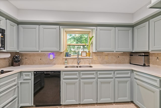 kitchen with light countertops, a sink, backsplash, and black appliances