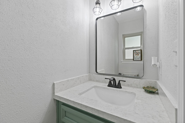 bathroom with a textured wall and vanity