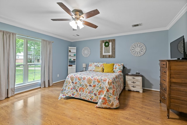bedroom featuring wood finished floors, visible vents, and crown molding