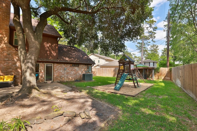 view of yard featuring a fenced backyard, central AC unit, and a playground