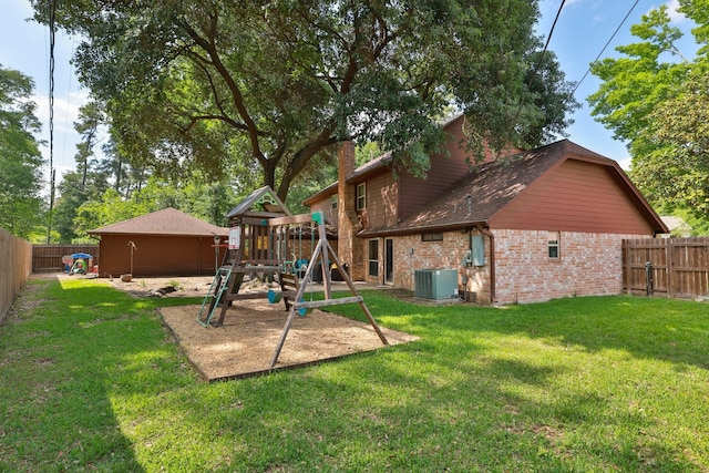 exterior space with brick siding, a yard, central air condition unit, and a playground