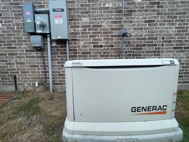 details with electric meter, a power unit, and brick siding
