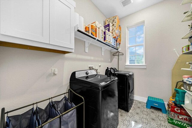 clothes washing area with visible vents, baseboards, independent washer and dryer, and cabinet space