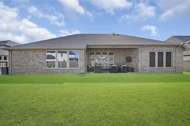 rear view of property featuring a yard, brick siding, an outdoor hangout area, and a patio area