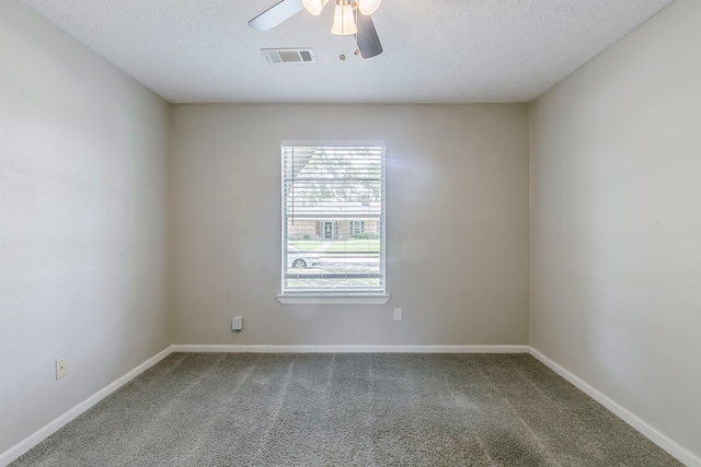 carpeted spare room featuring baseboards, a ceiling fan, and visible vents