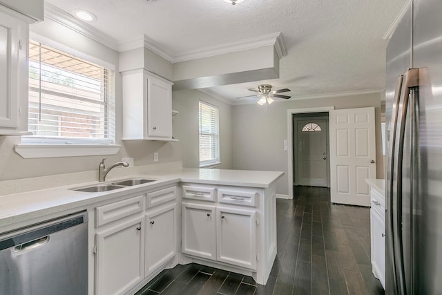 kitchen featuring a peninsula, light countertops, white cabinetry, a sink, and stainless steel appliances