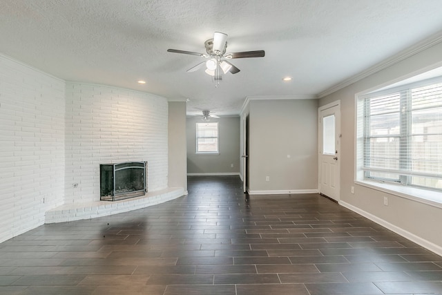 unfurnished living room with baseboards, a textured ceiling, a brick fireplace, and ceiling fan