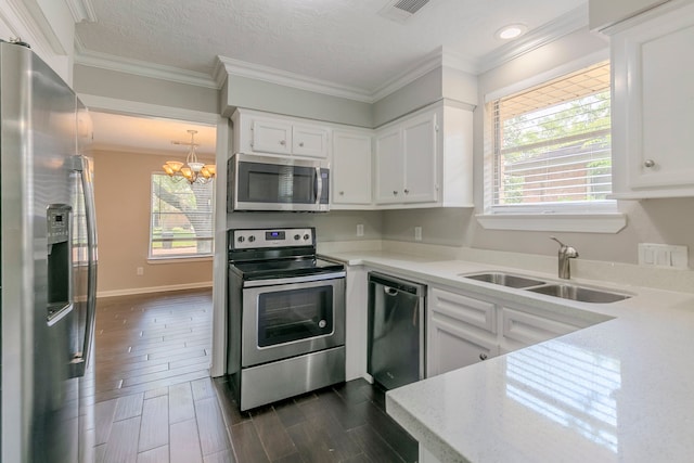 kitchen with appliances with stainless steel finishes, a sink, a chandelier, white cabinetry, and visible vents