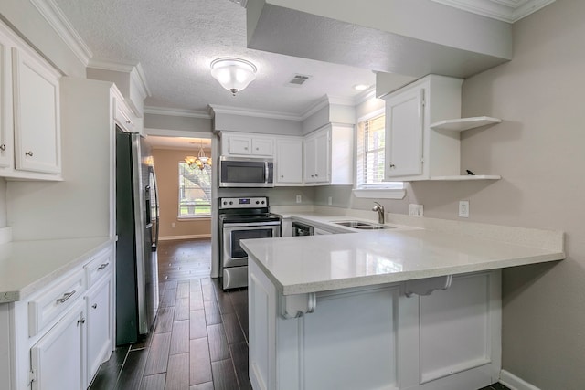 kitchen featuring open shelves, appliances with stainless steel finishes, a sink, a peninsula, and visible vents