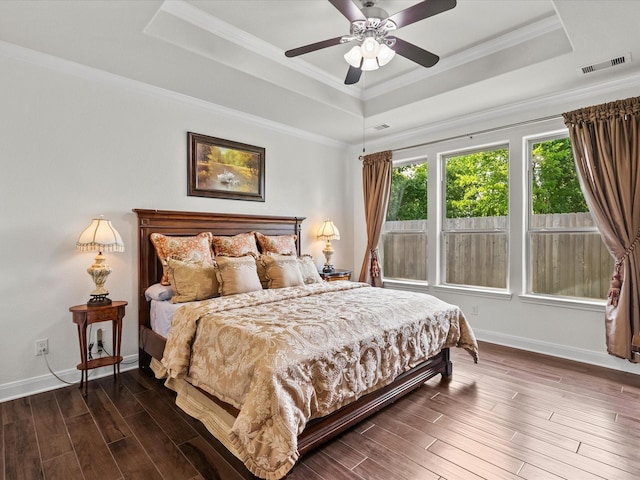 651 Tenuta Ln, League City, TX 77573 - bedroom with crown molding, visible vents, a tray ceiling, baseboards, and wood finished floors