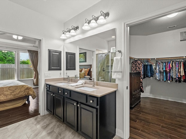651 Tenuta Ln, League City, TX 77573 - bathroom featuring wood finished floors, double vanity, and a sink
