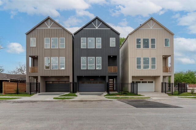 townhome / multi-family property featuring an attached garage, fence, and board and batten siding