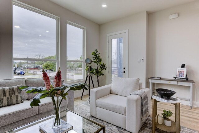 living room featuring recessed lighting, light wood-type flooring, and a healthy amount of sunlight