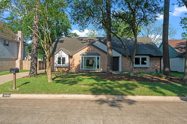 view of front of property featuring brick siding, a front yard, and fence