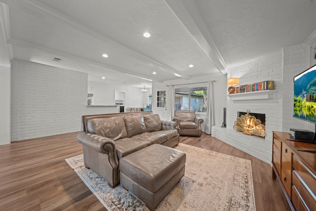 living area with wood finished floors, a textured ceiling, visible vents, and a fireplace