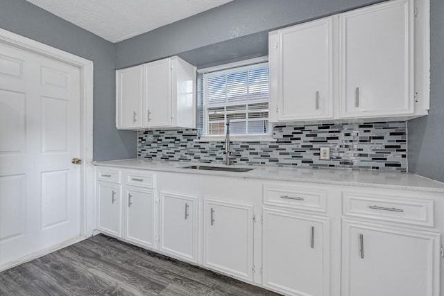 kitchen featuring a sink, decorative backsplash, and white cabinets