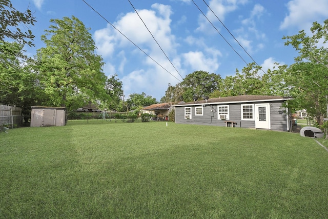 view of yard with fence, an outbuilding, and a storage unit