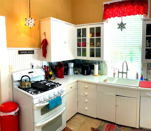 504 Gay Hill St, Brenham, TX 77833 - kitchen with tile countertops, light tile patterned floors, a sink, white appliances, and glass insert cabinets