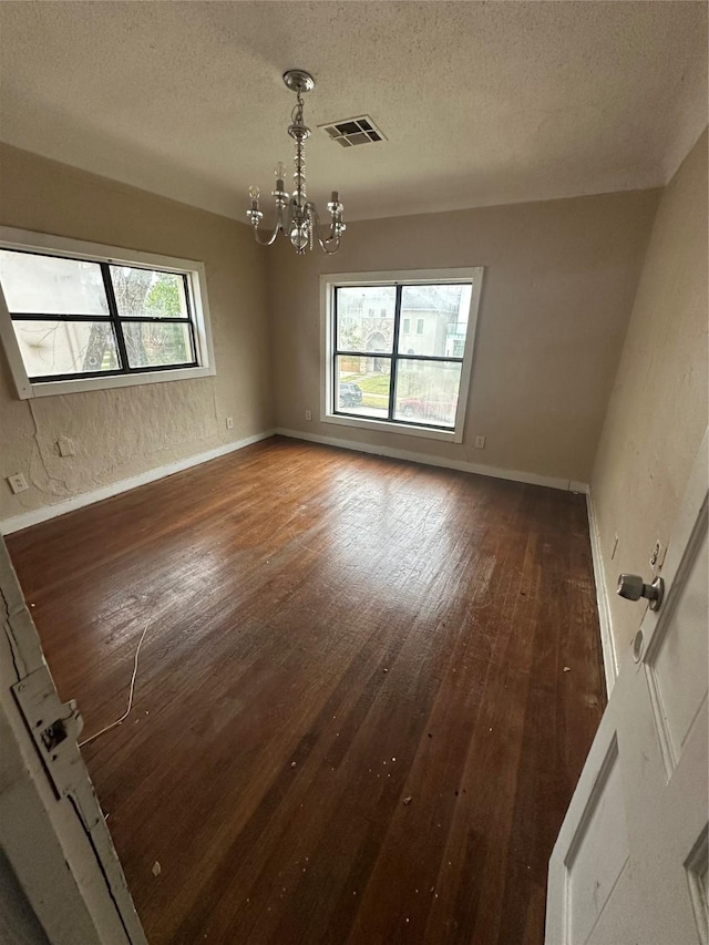 2038 Norfolk St Unit A, Houston, TX 77098 - spare room featuring an inviting chandelier, hardwood / wood-style flooring, a textured ceiling, and visible vents