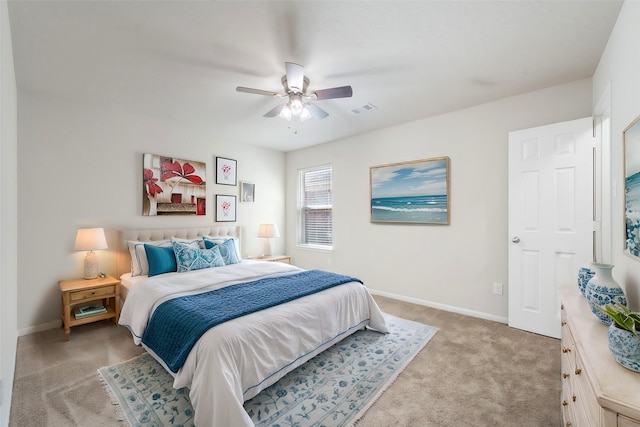 bedroom featuring baseboards, visible vents, a ceiling fan, and light colored carpet