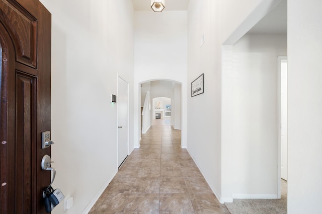 hallway with arched walkways and baseboards