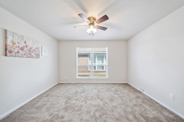 carpeted empty room featuring baseboards, a ceiling fan, and a textured ceiling