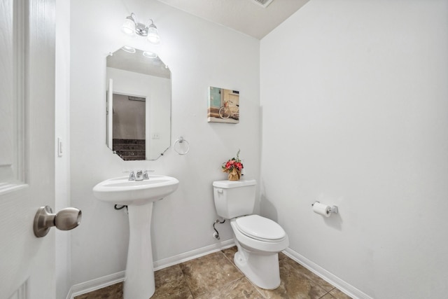 bathroom with toilet, tile patterned flooring, a sink, and baseboards