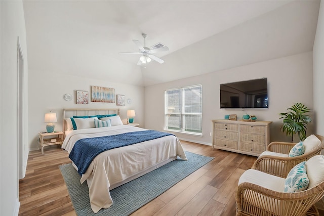 bedroom featuring vaulted ceiling, wood finished floors, ceiling fan, baseboards, and visible vents