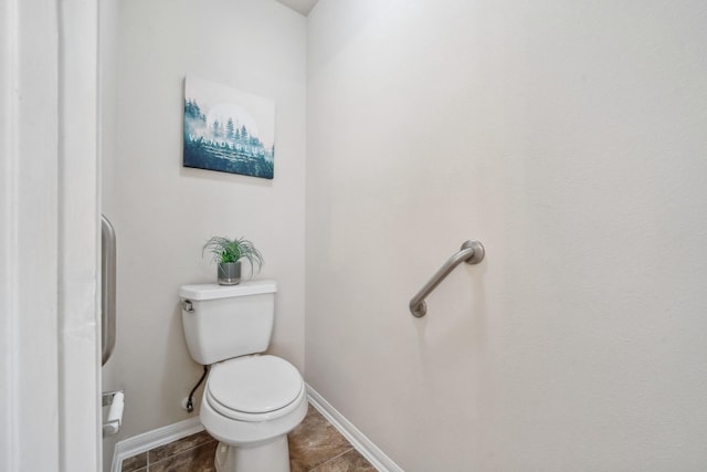 bathroom featuring toilet, baseboards, and tile patterned floors