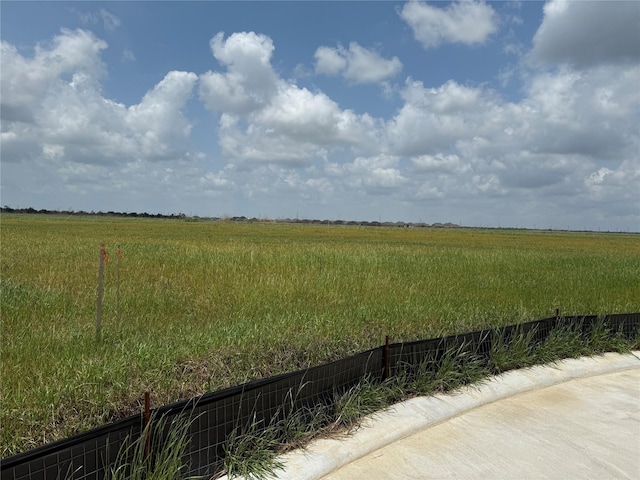 view of yard featuring fence and a rural view