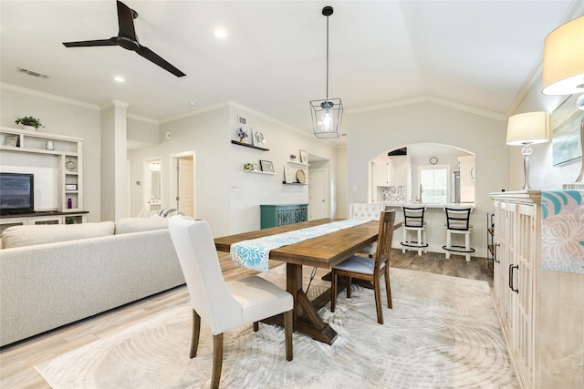 29 Clara Barton Ln, Galveston, TX 77551 - dining space featuring light wood finished floors, arched walkways, a ceiling fan, visible vents, and ornamental molding