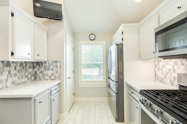 29 Clara Barton Ln, Galveston, TX 77551 - kitchen with backsplash, appliances with stainless steel finishes, light countertops, baseboards, and white cabinets