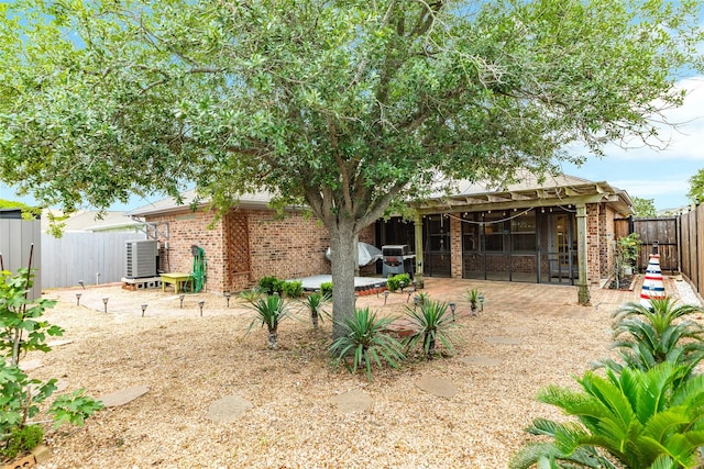 29 Clara Barton Ln, Galveston, TX 77551 - rear view of house with a fenced backyard, a patio, central AC unit, and brick siding