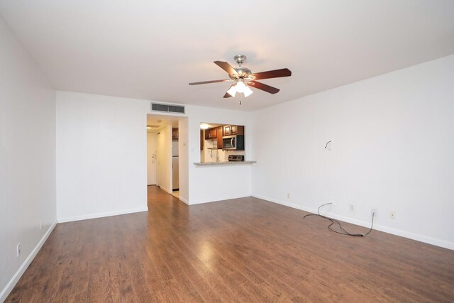 unfurnished living room with baseboards, a ceiling fan, visible vents, and dark wood-style floors