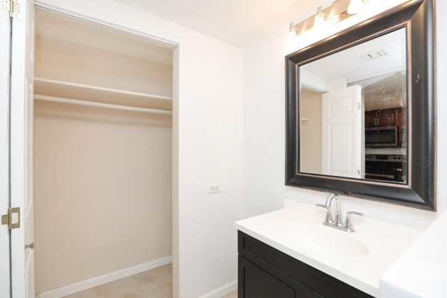 bathroom featuring baseboards, tile patterned flooring, and vanity