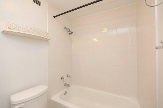 bathroom featuring toilet, shower / bath combination, and visible vents