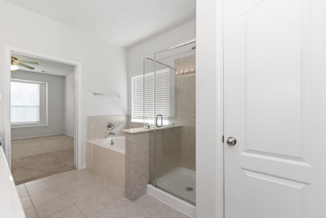 full bath featuring a bath, tile patterned floors, a ceiling fan, and a shower stall