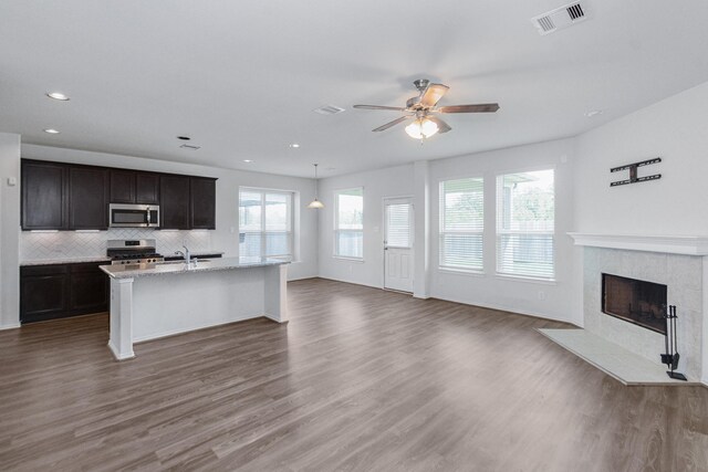 kitchen featuring wood finished floors, visible vents, a sink, appliances with stainless steel finishes, and open floor plan