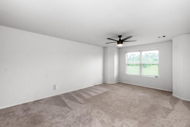 unfurnished room with carpet flooring, a ceiling fan, baseboards, and visible vents
