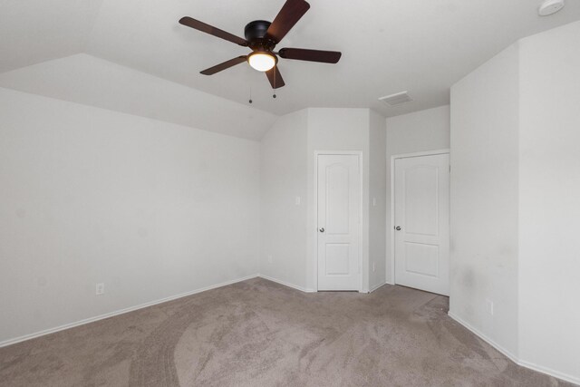 unfurnished bedroom with vaulted ceiling, a ceiling fan, baseboards, carpet flooring, and visible vents