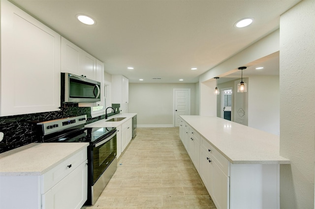 kitchen with recessed lighting, a sink, stainless steel appliances, decorative backsplash, and light countertops
