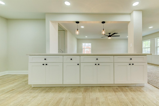 kitchen featuring light wood finished floors, ceiling fan, decorative light fixtures, and white cabinetry