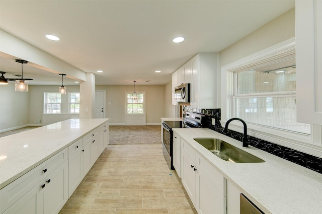 kitchen with recessed lighting, a sink, white cabinetry, and stainless steel appliances