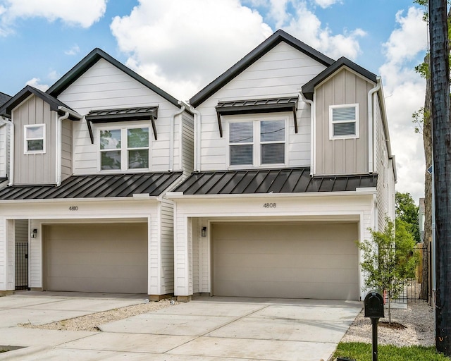 townhome / multi-family property featuring board and batten siding, a standing seam roof, and a garage