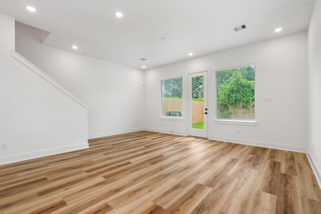 unfurnished living room featuring baseboards, recessed lighting, visible vents, and light wood-type flooring