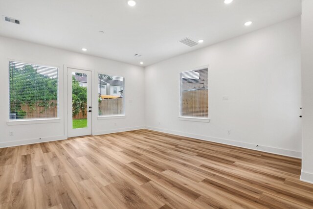 empty room featuring baseboards, light wood finished floors, visible vents, and recessed lighting