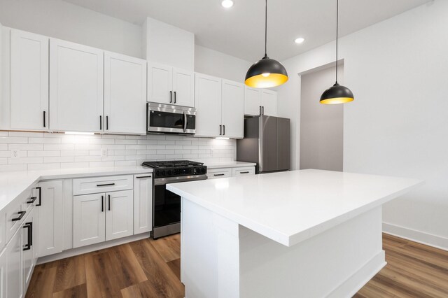 kitchen with tasteful backsplash, white cabinets, appliances with stainless steel finishes, dark wood-type flooring, and recessed lighting