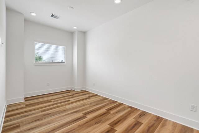 spare room with light wood finished floors, baseboards, visible vents, and recessed lighting