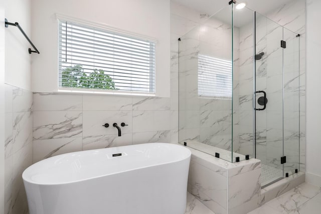 bathroom featuring tile walls, a soaking tub, marble finish floor, and a marble finish shower