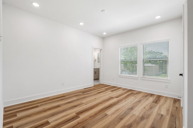 spare room with recessed lighting, light wood finished floors, and baseboards